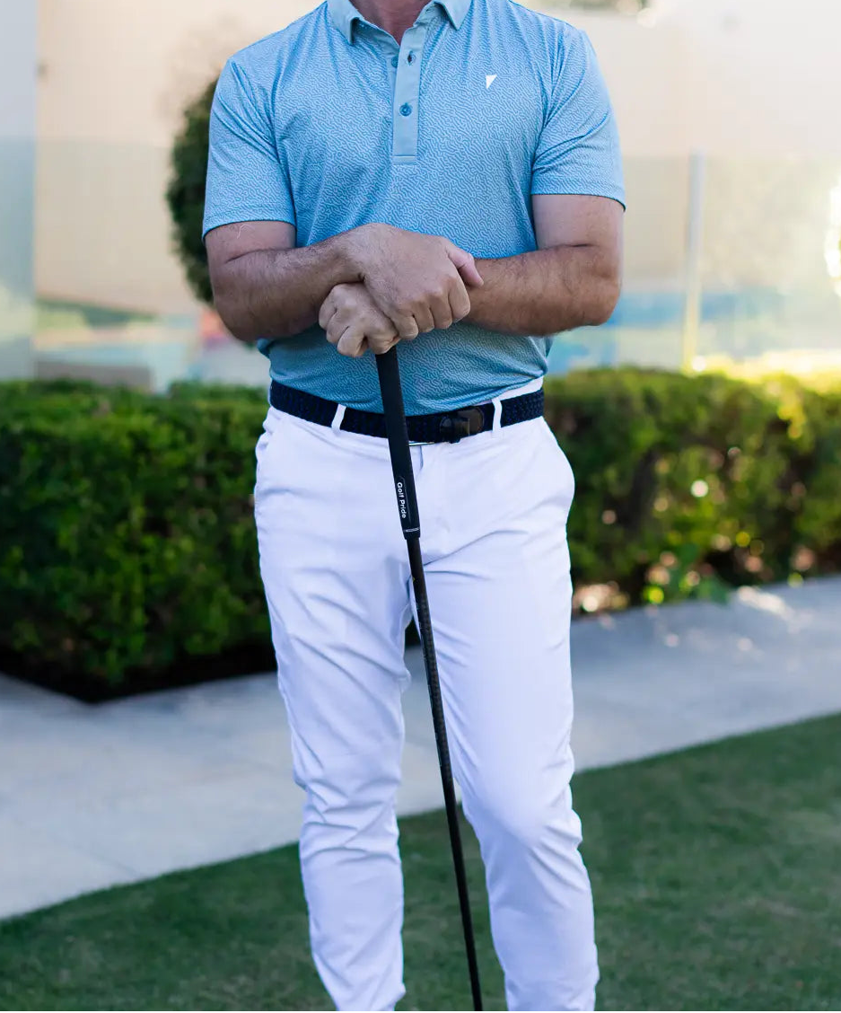 Man in golf attire holding a club on a golf course