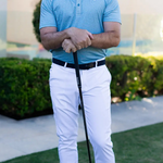 Man in golf attire holding a club on a golf course