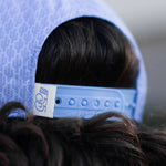 Close-up of a blue cap with a brand label on a blurred background