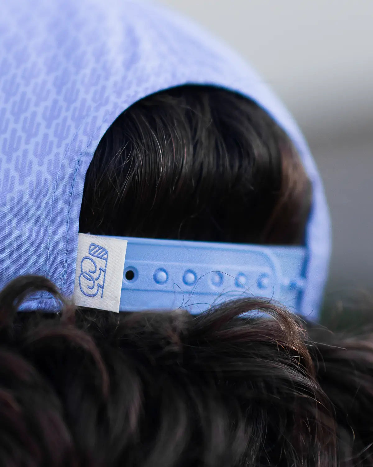 Close-up of a blue cap with a brand label on a blurred background