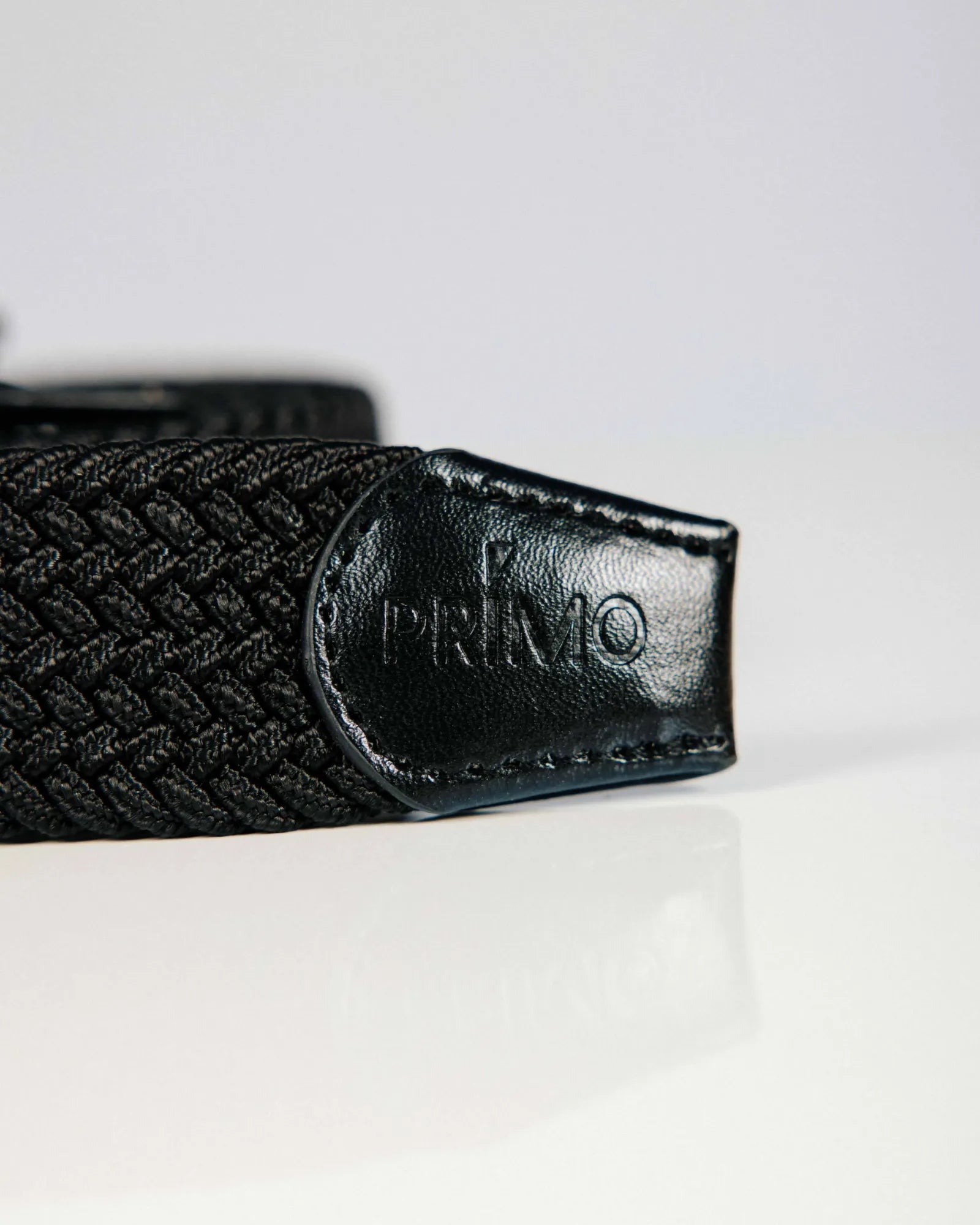 Black woven belt with 'PRIMO' logo on a white background