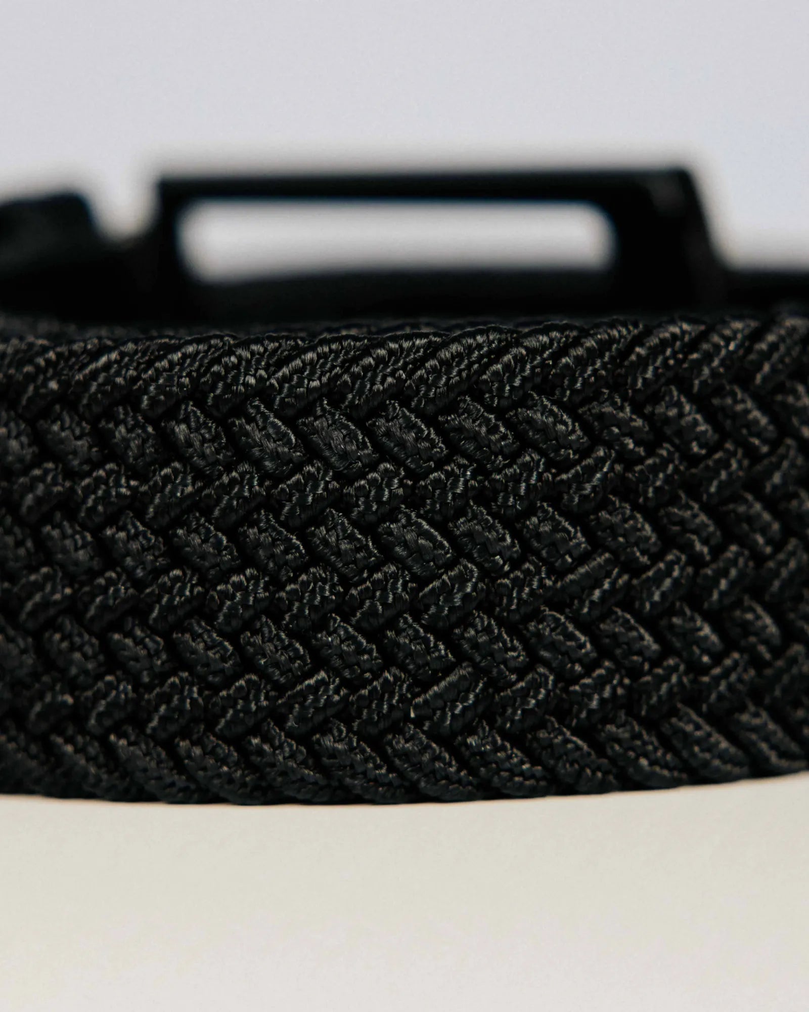 Black braided belt on a light background
