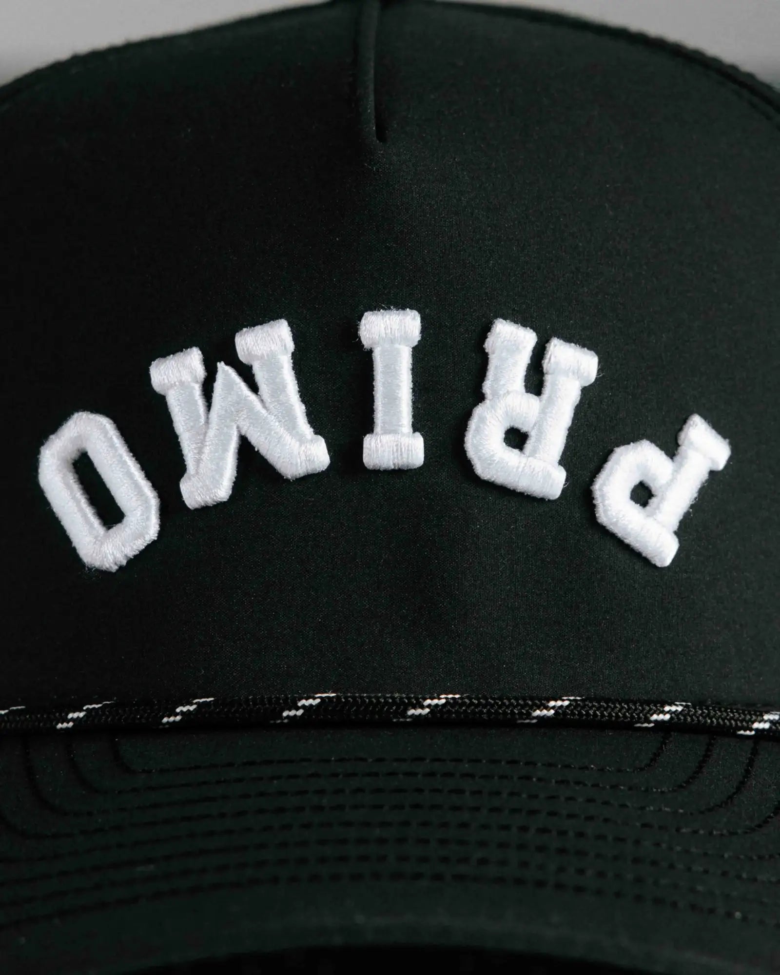 Black cap with 'PRIMO' embroidered in white on a plain background