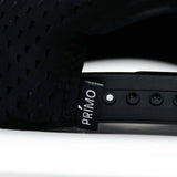Close-up of a black seat with 'Primo' branding on a white background