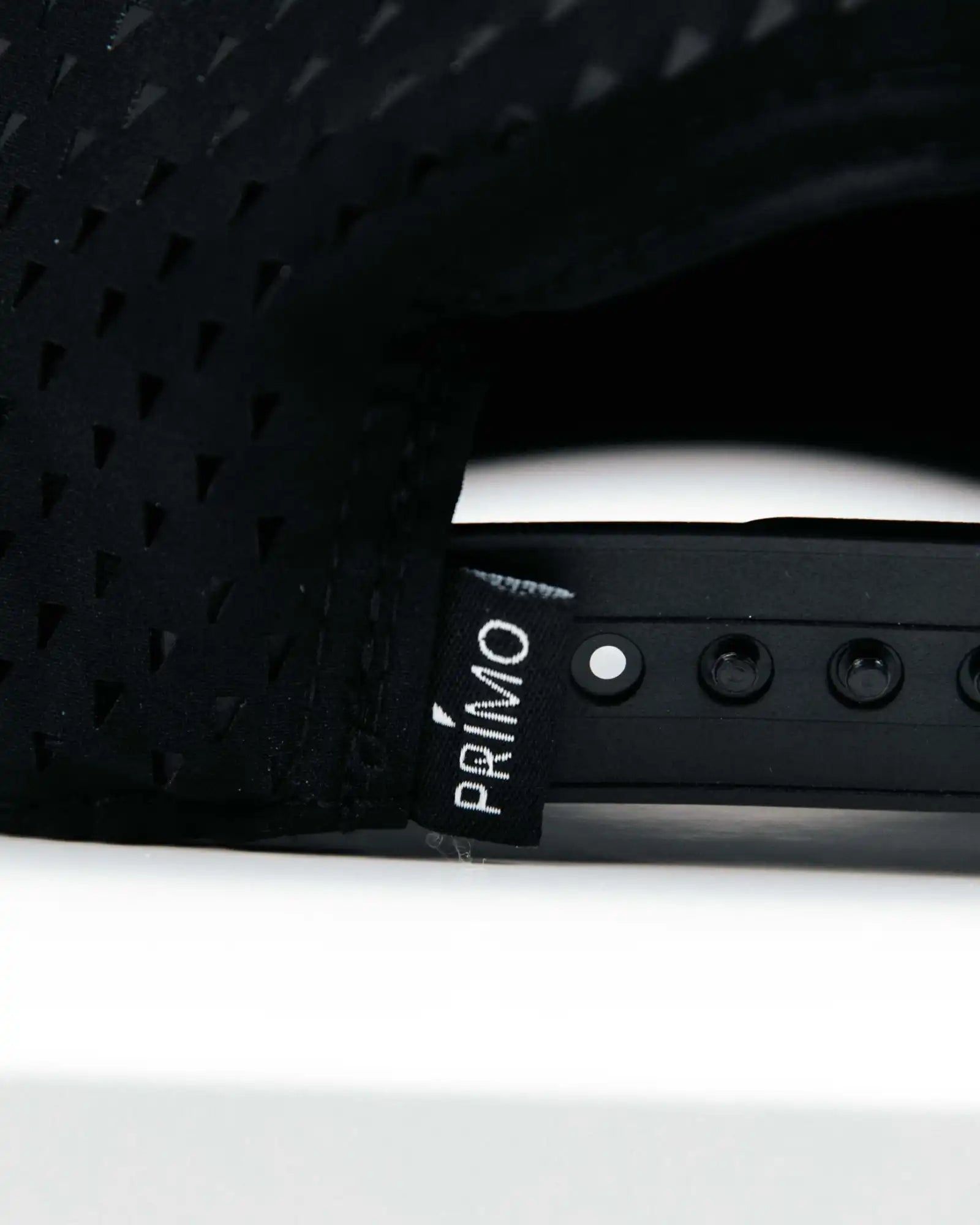 Close-up of a black seat with 'Primo' branding on a white background