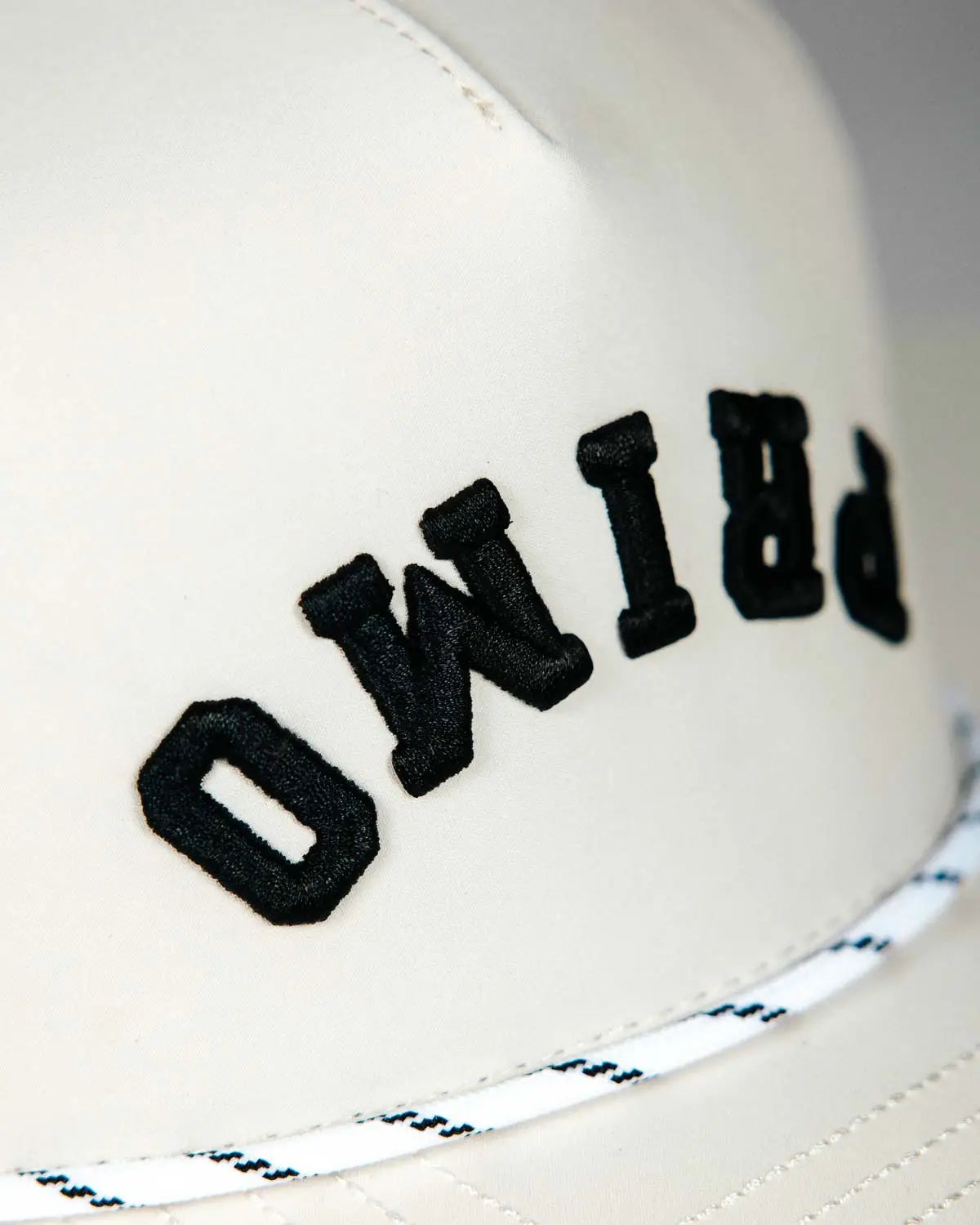 Side view of Primo embroidered logo on front of golf hat