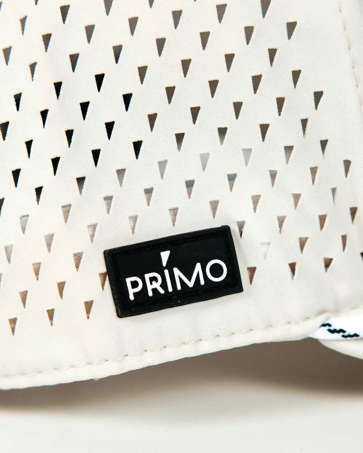 Primo rubber logo label sewn to side of cap