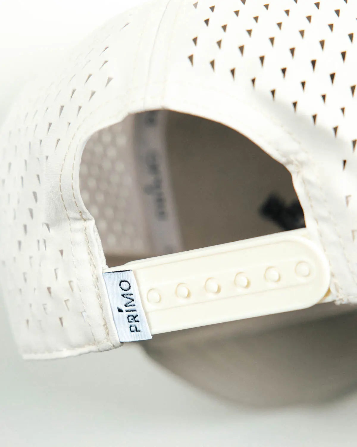 Close up detail of back of cap with mesh and snapback closure.