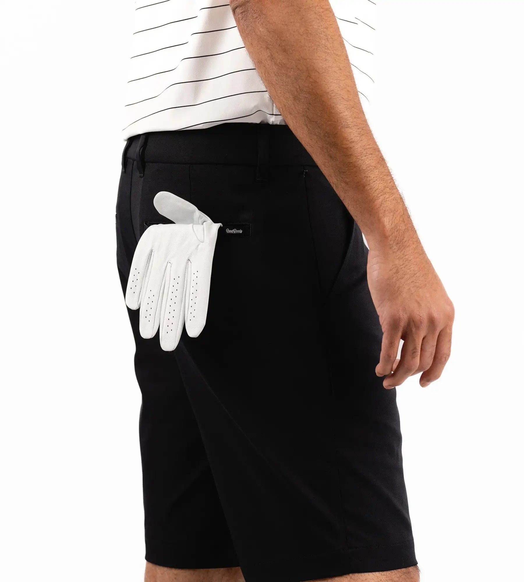Person wearing black shorts with a white golf glove in the pocket on a white background