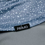 Close-up of a blue speckled fabric with a Primo label.