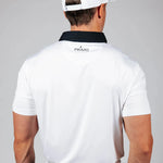 Man wearing a white polo shirt with 'Primo' logo on the back against a gray background