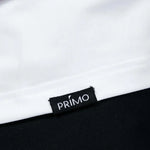 Close-up of a 'Primo' label on a garment with a white and black background.