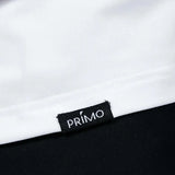 Close-up of a 'Primo' label on a garment with a white and black background.