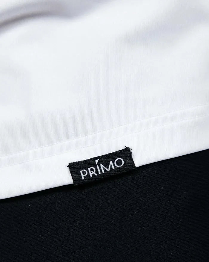 Close-up of a 'Primo' label on a garment with a white and black background.