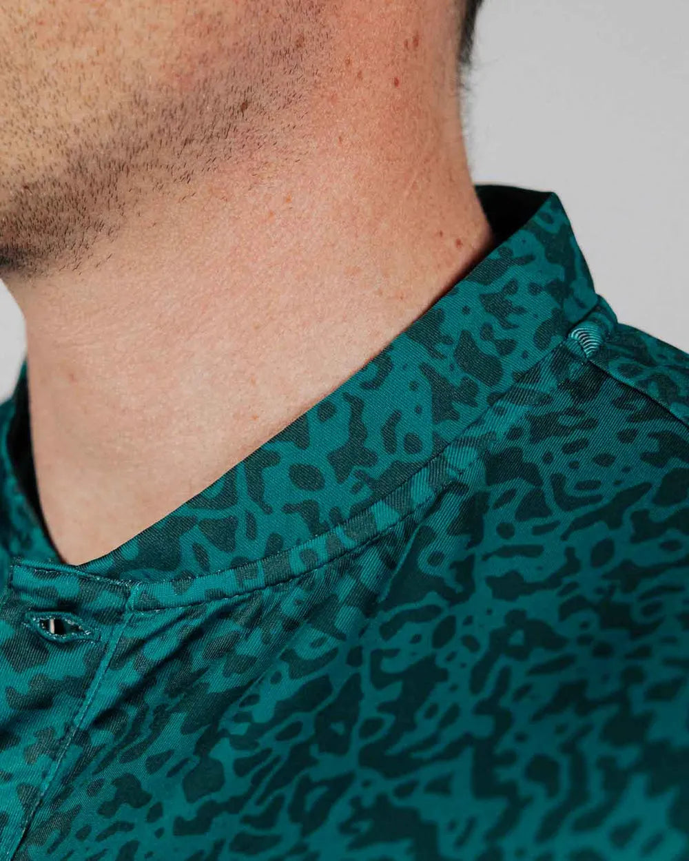 Close-up of a person wearing a green camouflage-patterned shirt.
