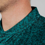 Close-up of a person wearing a green camouflage-patterned shirt.
