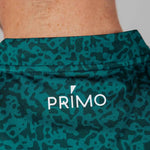 Green patterned fabric with 'Primo' logo on a close-up of skin.