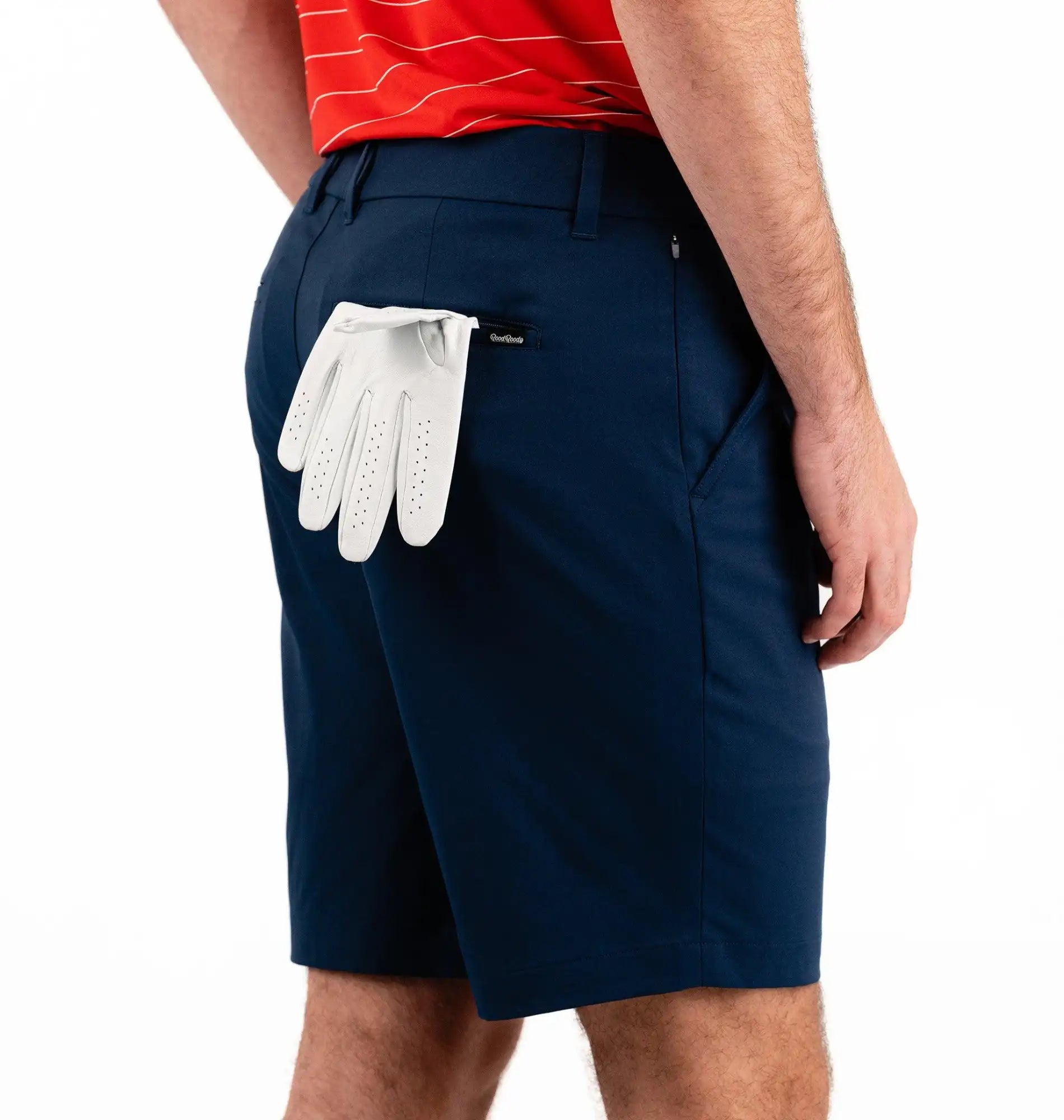 Person wearing navy shorts with a white golf glove in the pocket on a white background