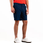 Person wearing navy shorts and a red shirt on a white background