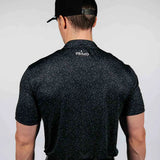 Man wearing a black speckled shirt with 'PRIMO' branding on the back, against a white background