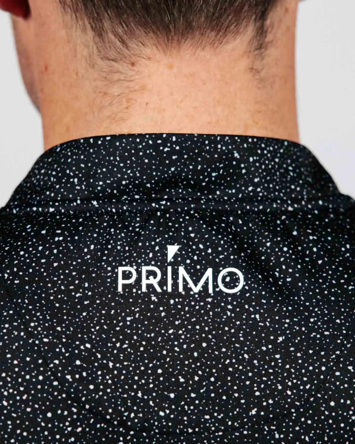 Black speckled shirt with 'PRIMO' logo on a plain background