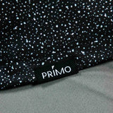 Close-up of a black polo with white speckles and a 'Primo' label.