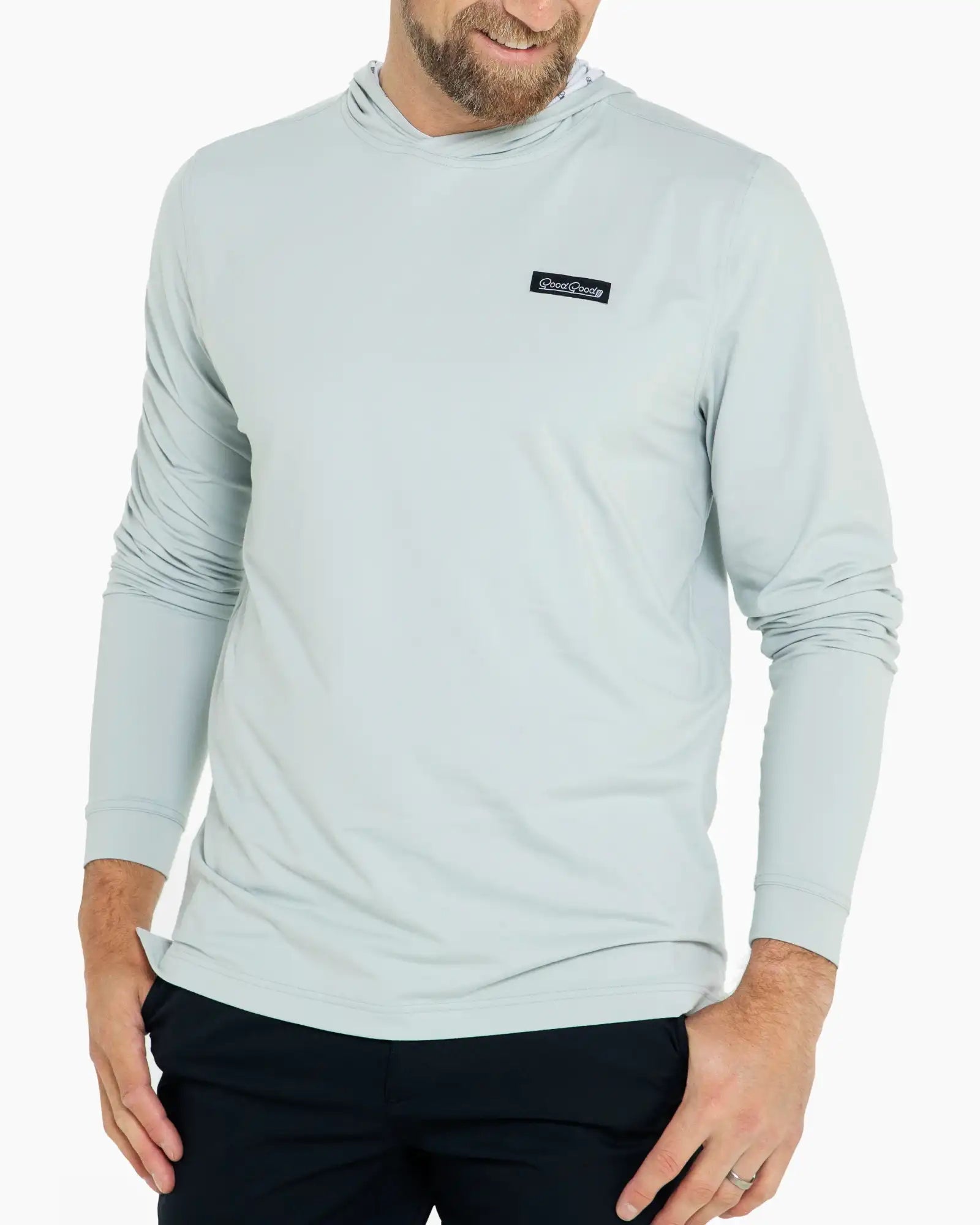 Man wearing a light blue long-sleeve shirt with a brand logo on a white background