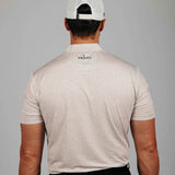 Man wearing a beige patterned shirt with 'Primo' branding on the back, against a gray background.