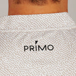 Sand coloured patterned shirt with 'PRIMO' logo on a neutral background