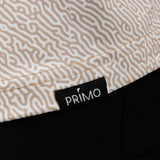Close-up of a patterned fabric with a 'Primo' label on a black background