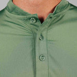 Close-up of a green polo shirt with buttons on a gray background