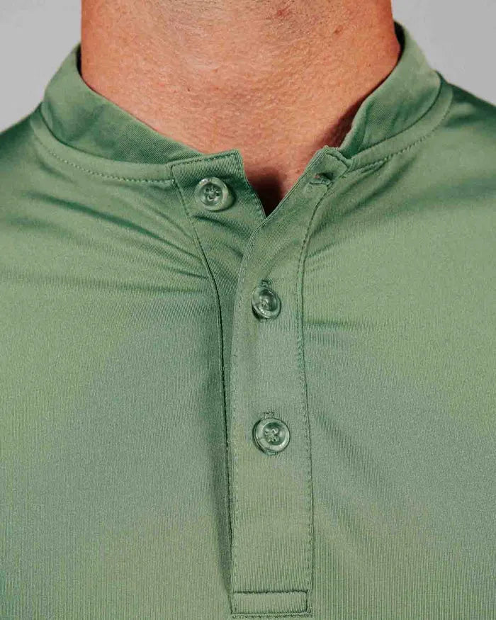 Close-up of a green polo shirt with buttons on a gray background
