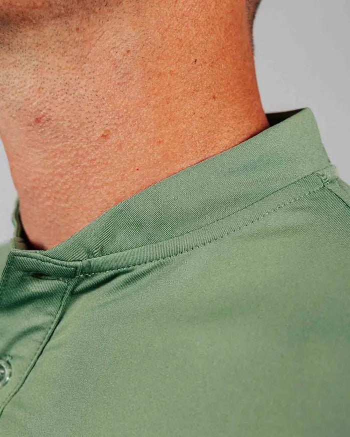 Close-up of a green shirt mock collar with a neutral background
