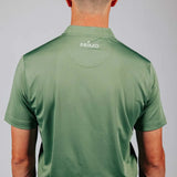 Person wearing a green 'Primo' polo shirt with a plain background