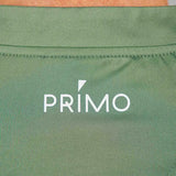 Back of green polo with 'PRIMO' logo in white
