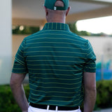 Man wearing a green striped polo shirt and cap, standing outdoors.