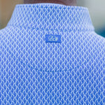 Close-up of a blue textured shirt with a logo on the chest.