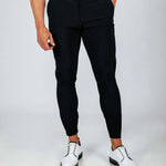 Person wearing black pants and white shoes on a plain background