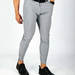 Person wearing gray pants and black shoes on a white background