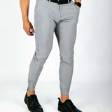 Person wearing gray pants and black shoes on a white background
