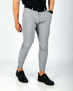 Person wearing gray pants and black shoes on a white background