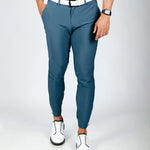 Person wearing blue pants and white shoes on a plain background