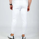 Person wearing white pants on a plain background