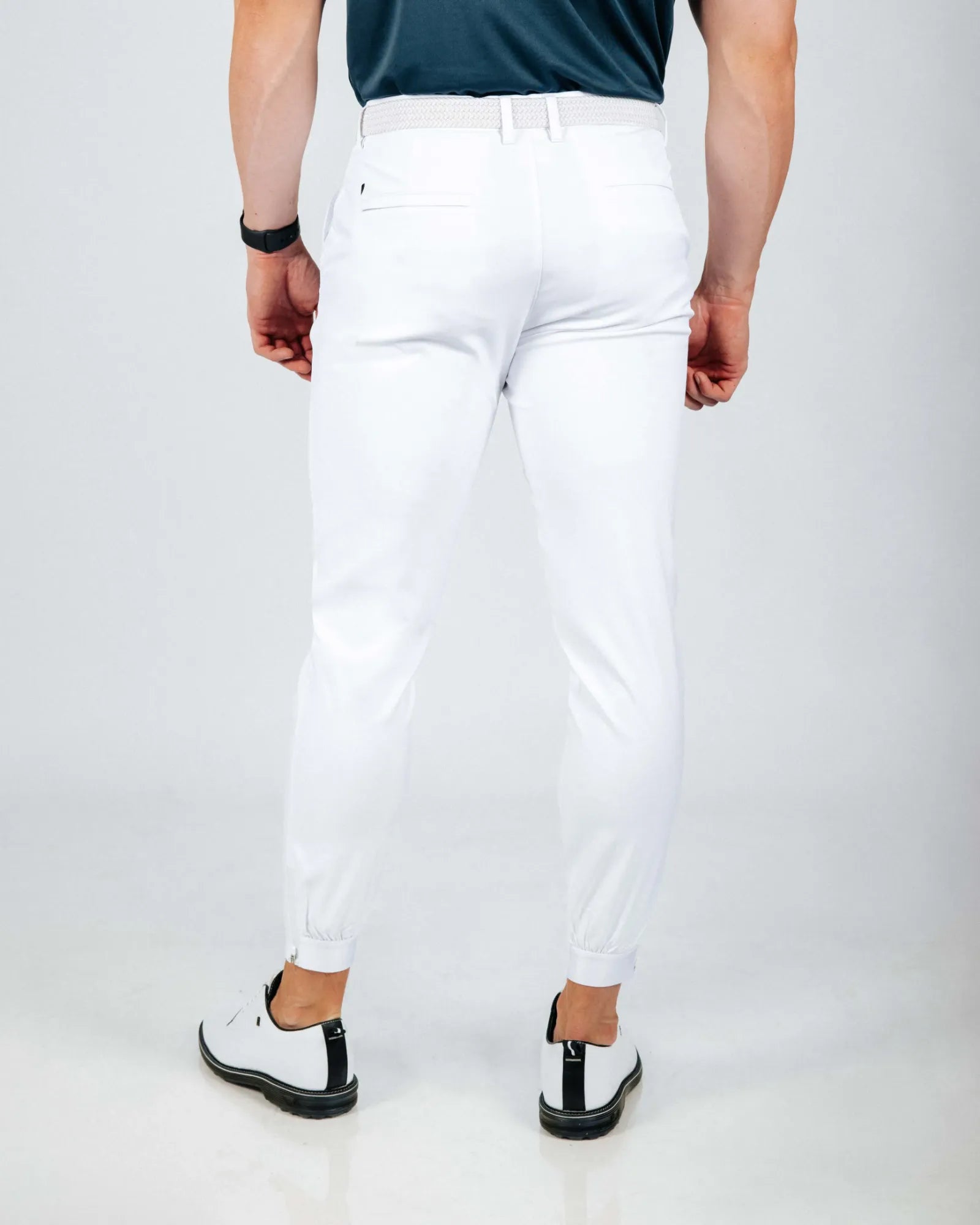 Person wearing white pants on a plain background