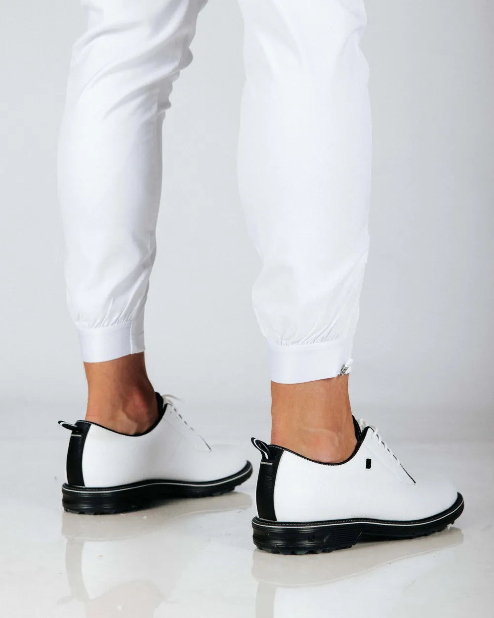 Back view close up of white pants and cuffed hems.