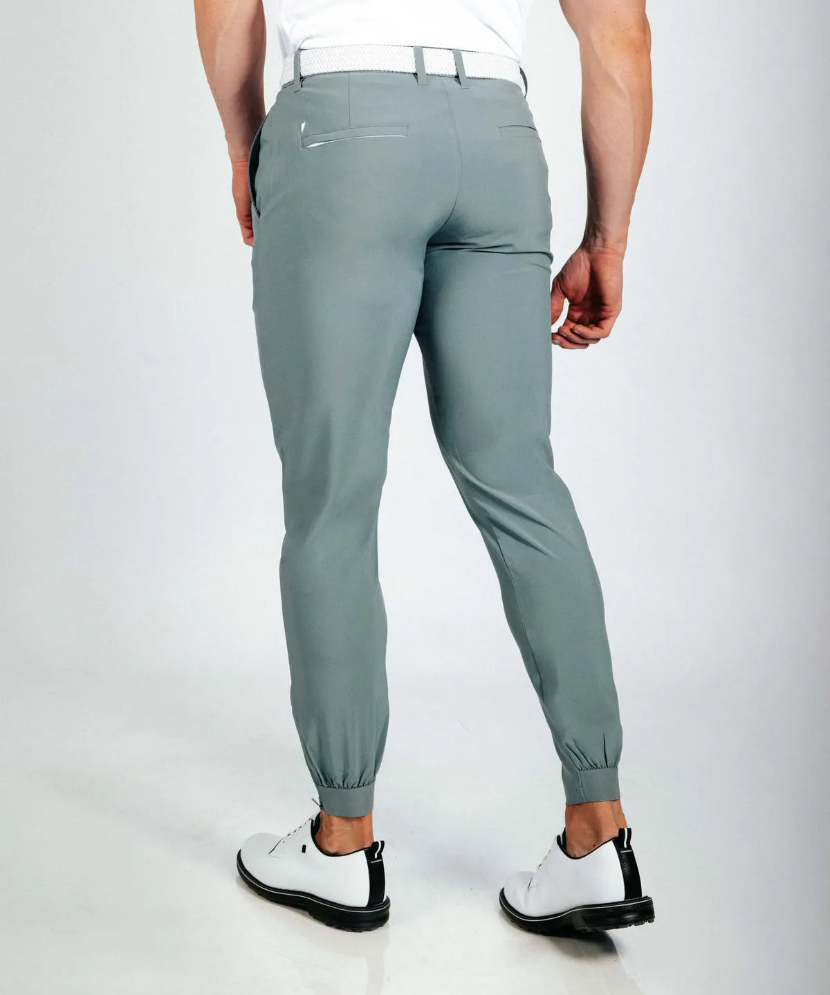 Person wearing green jogger pants on a white background