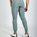 Person wearing green jogger pants on a white background