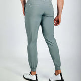 Person wearing green jogger pants on a white background
