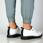 Close up of cuffed hem of pants with side zip. Model also wearing white golf shoes