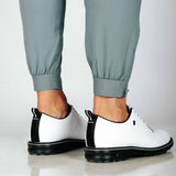 Close up of cuffed hem of pants with side zip. Model also wearing white golf shoes